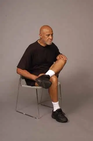 Ankle-over-knee piriformis stretch on chair